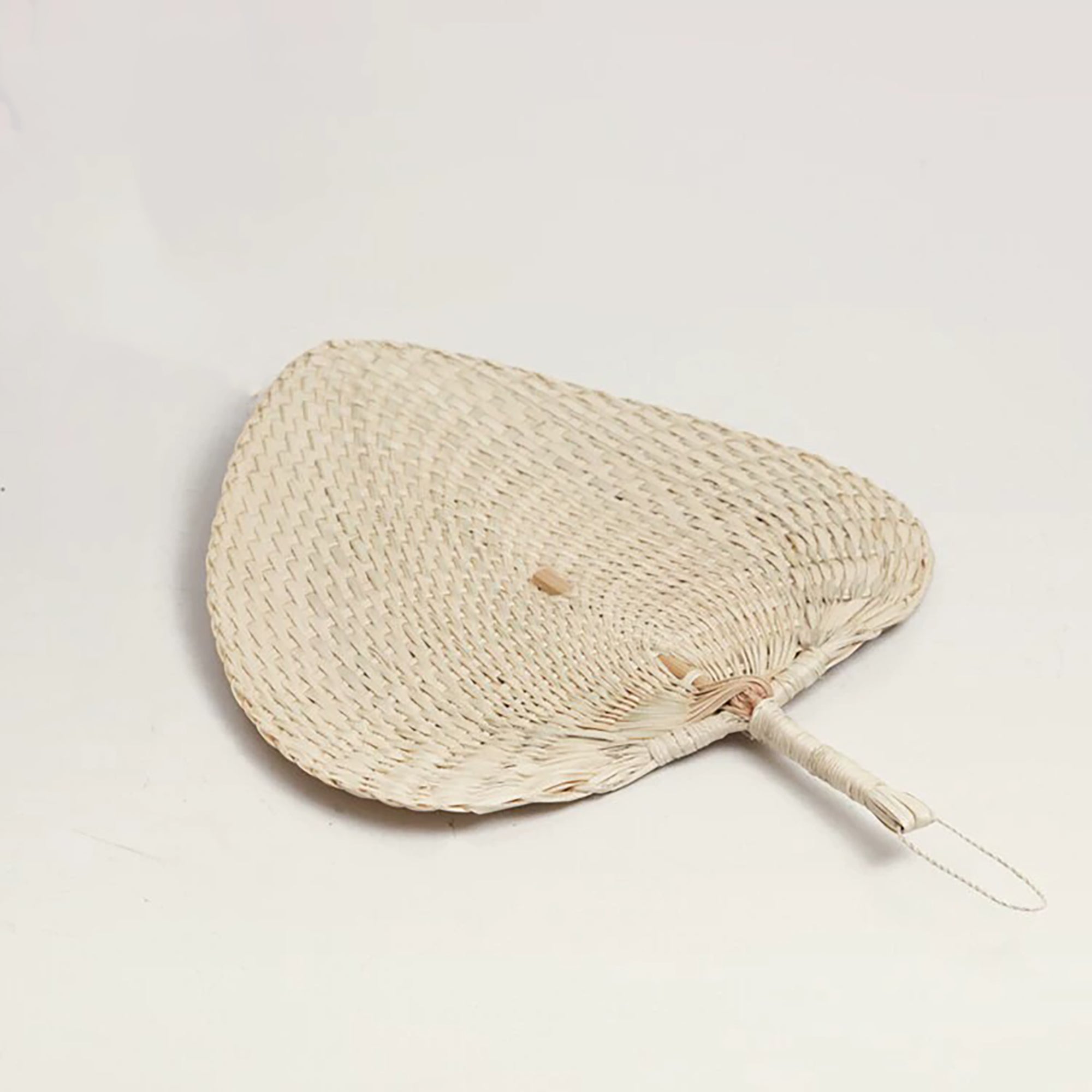 Éventail traditionnel en feuille de palmier tressée