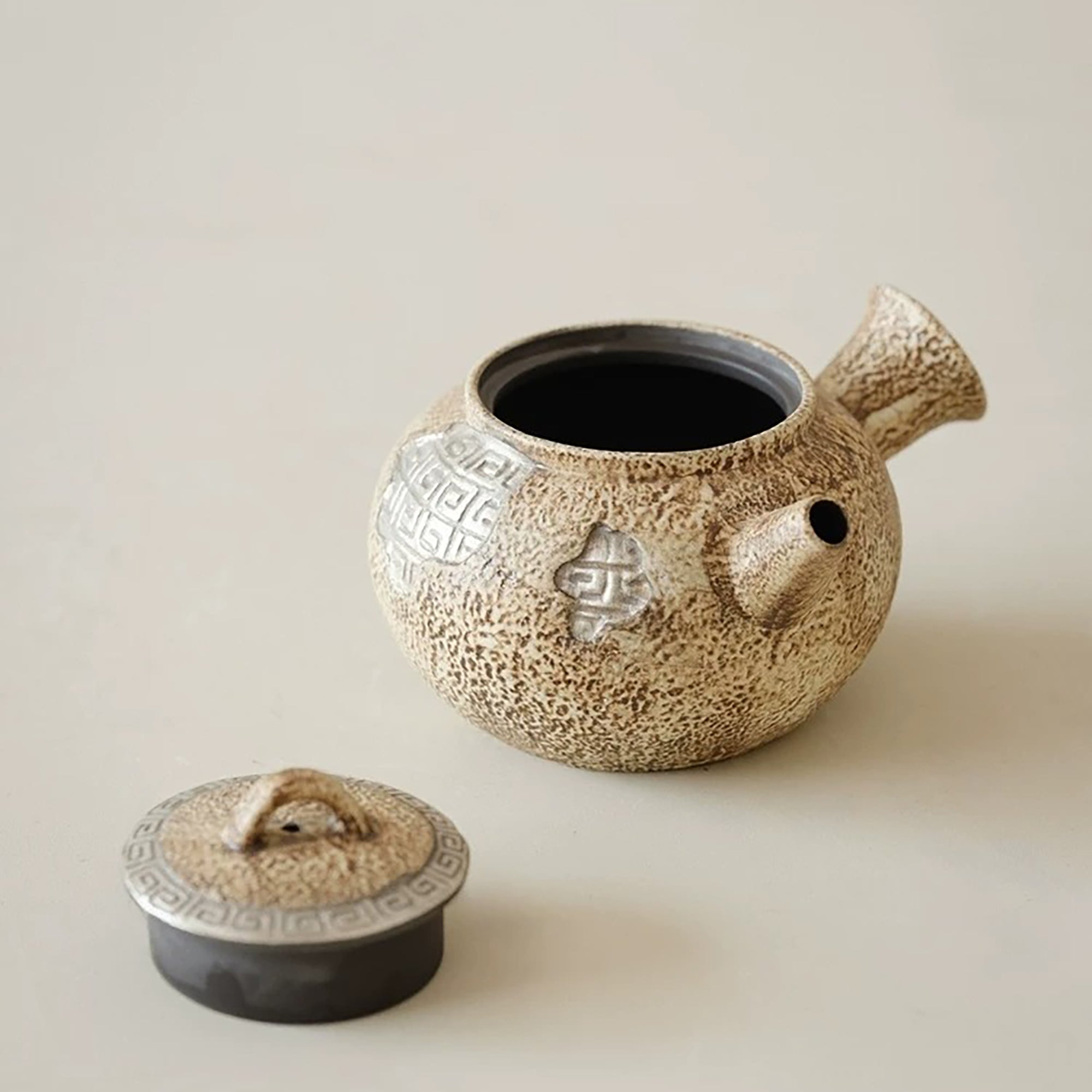 Théière artisanale effet pierre avec décor méandre argenté