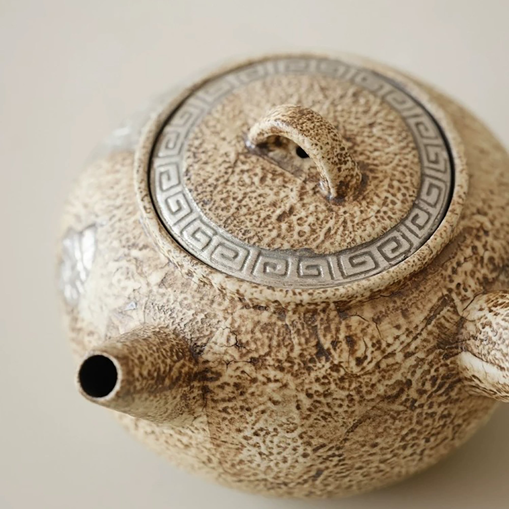 Théière artisanale effet pierre avec décor méandre argenté