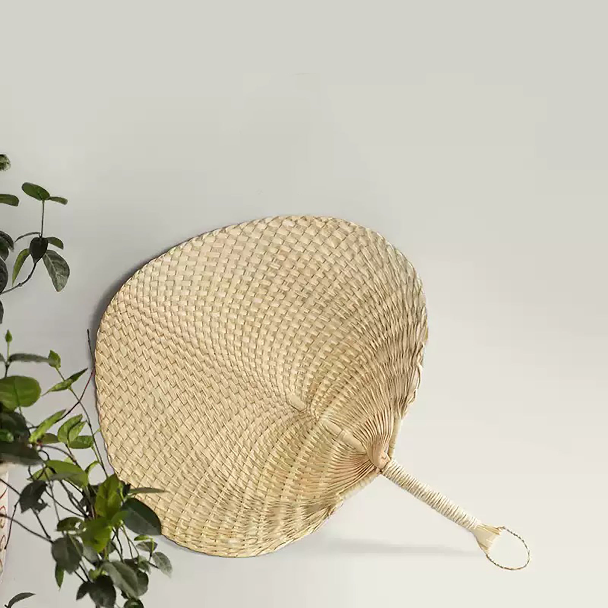 Éventail traditionnel en feuille de palmier tressée 