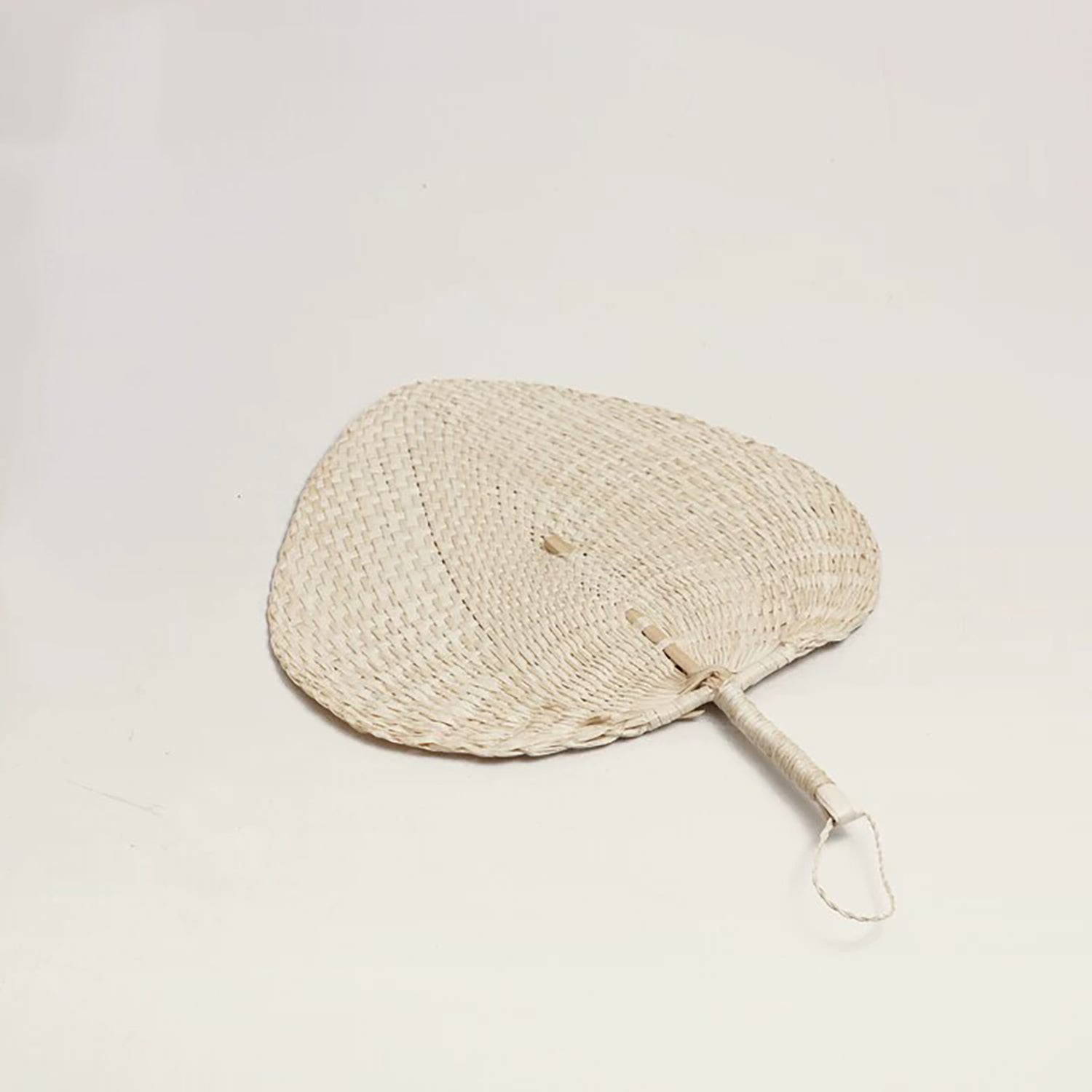 Éventail traditionnel en feuille de palmier tressée 