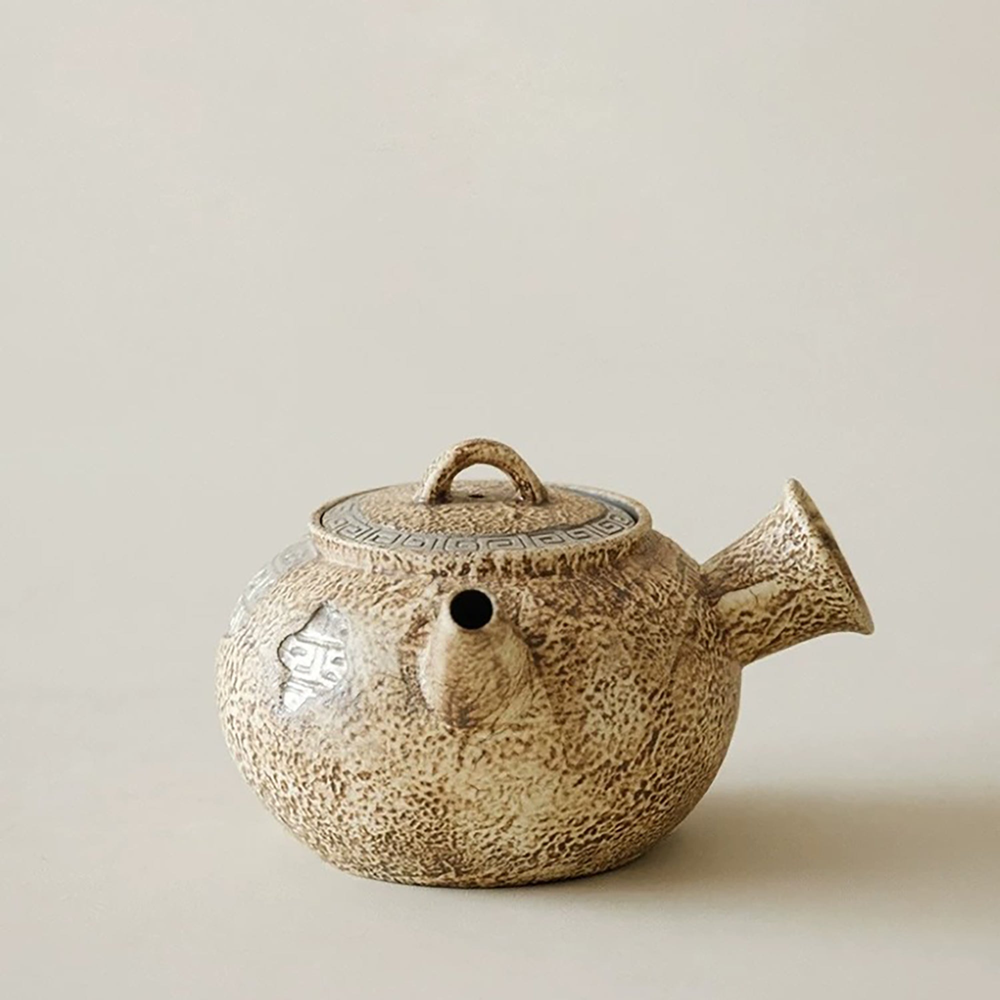 Théière artisanale effet pierre avec décor méandre argenté
