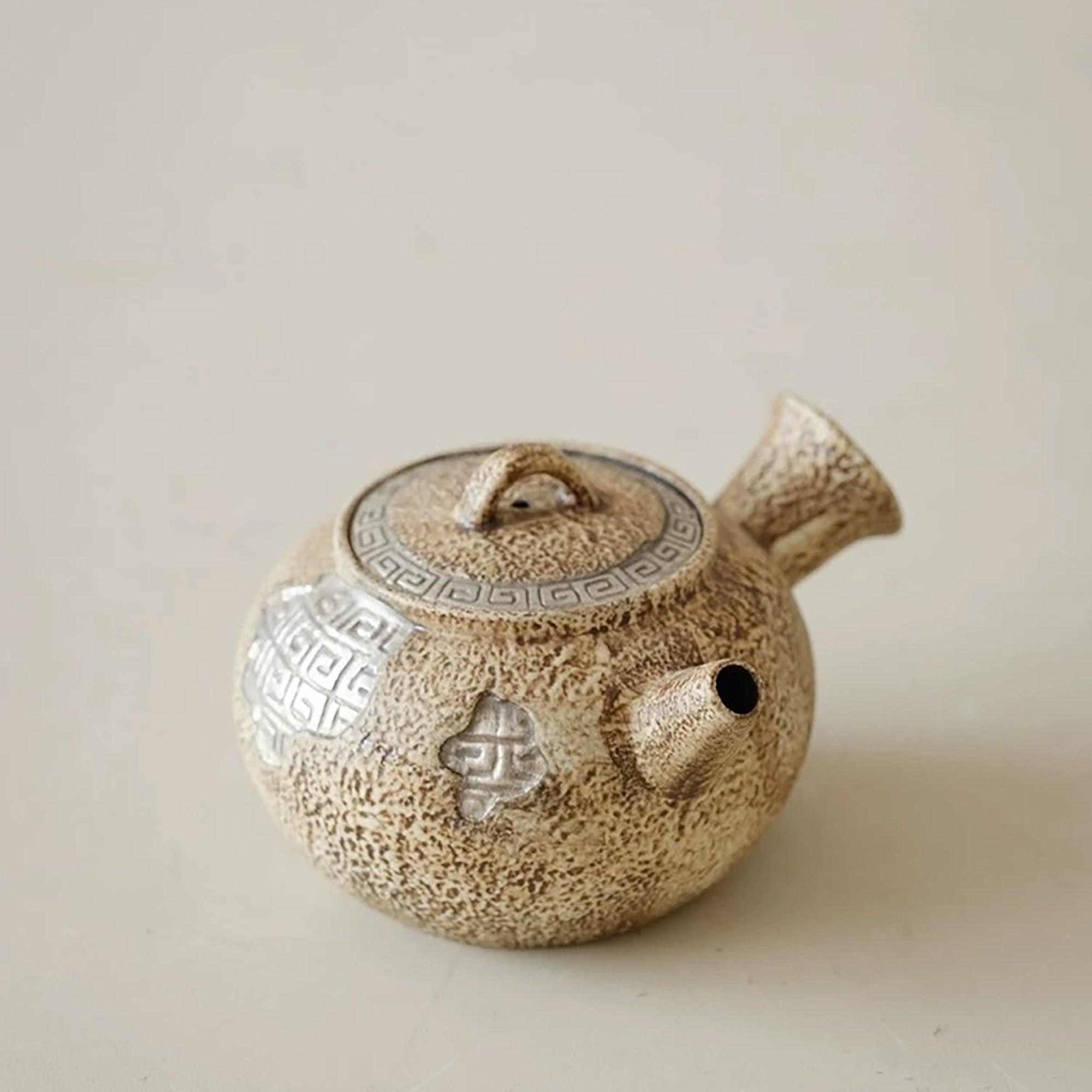 Théière artisanale effet pierre avec décor méandre argenté
